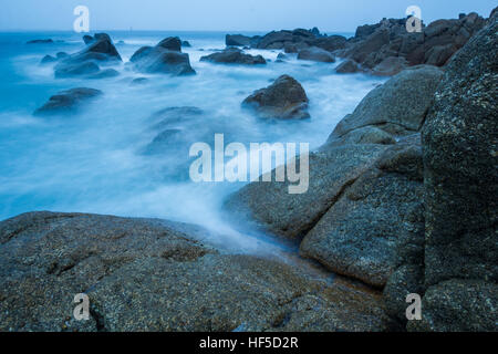 Una lunga esposizione di lavaggio delle onde sulle rocce Foto Stock