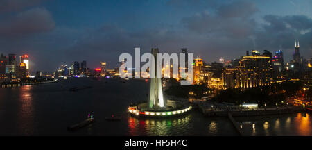 Vista notturna di Bund skyline dominata dal monumento a persone di eroi dal fiume Huangpu, Shanghai, Cina Foto Stock