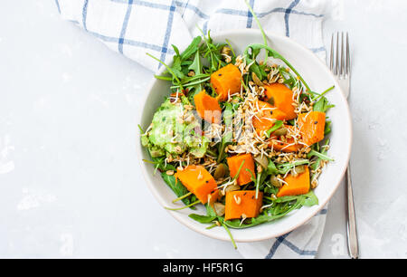 Insalata verde con patate dolci, guacamole e olive. Vegano sano il pranzo o la cena. Amore per un sano cibo crudo concetto. Foto Stock