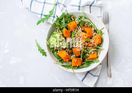 Insalata verde con patate dolci, guacamole e olive. Vegano sano il pranzo o la cena. Amore per un sano cibo crudo concetto. Foto Stock