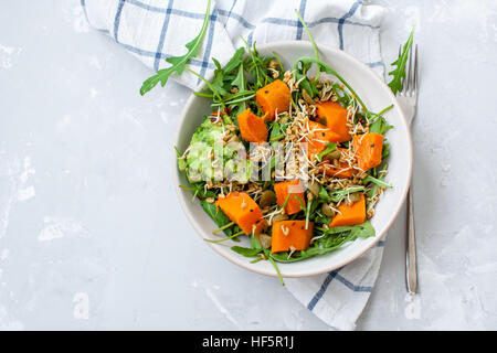 Insalata verde con patate dolci, guacamole e olive. Vegano sano il pranzo o la cena. Amore per un sano cibo crudo concetto. Foto Stock