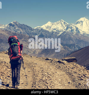 Lonely trekker camminando sulla strada del deserto. Foto Stock