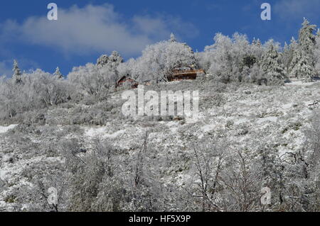 Casa sulla cima della montagna nella neve Foto Stock