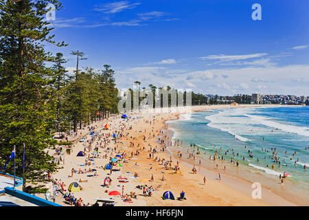 Nord di Sydney Manly principale spiaggia fronte oceano pacifico su una soleggiata giornata estiva con la folla di turisti e beachgoers rilassante e surf. Foto Stock