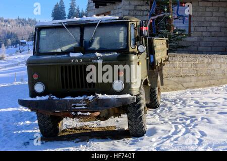 Vecchio macchinario arrugginito abbandonato nella neve in inverno Foto Stock