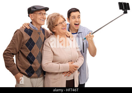 Allegro seniors e un giovane uomo prendendo un selfie con un bastone isolato su sfondo bianco Foto Stock