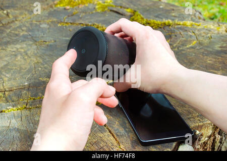 Uomo con le mani in mano girando sull'altoparlante senza fili Foto Stock