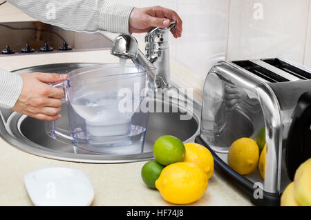 Caraffa filtrante per acqua con limone e vetro sul tavolo della