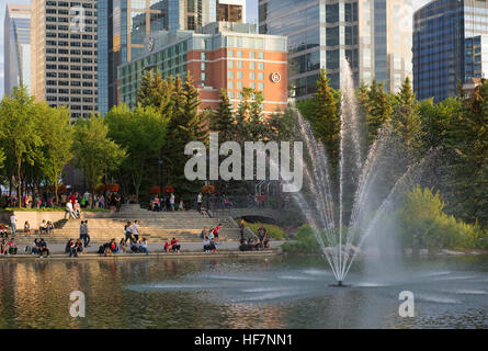 Le persone che visitano laguna con fontana in Eau Claire area del centro cittadino di Calgary in Canada giorno Foto Stock