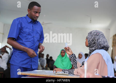 Il 23 novembre 2016, un funzionario elettorale verifica l'identità di un delegato durante il processo elettorale per la selezione dei membri del Parlamento federale della camera bassa somala a Garowe. Foto Stock