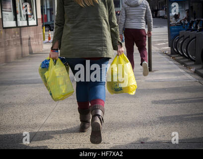 Una shopper con il suo supermercato di sacchetti di plastica in New York Venerdì, Dicembre 23, 2016. Dopo un ritardo nelle pagine precedenti di questo anno la città di New York il sacchetto in plastica bill, richiedendo un 5 cent tassa sui sacchetti di plastica usa e getta, viene impostato per avere effetto nel febbraio 2017. (© Richard B. Levine) Foto Stock