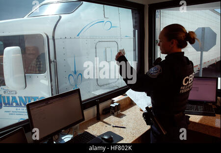 Un U.S. Customs and Border Protection Officer controlla la identificazione del conducente di autocarri come egli passa attraverso i checkpoint degli Stati Uniti del carico Pre-Inspection all'Otay Mesa, California, la porta di entrata, 22 giugno 2016. In un dato giorno, diverse centinaia di camion line up sul lato messicano del confine per consegnare le importazioni in definitiva in attesa del processo di screening tramite i funzionari della dogana. Un numero crescente di società di navigazione sono approfittando di CBP's Cargo Pre-Inspection che consente di mittenti attendibili un più veloce e più efficiente dei mezzi di erogazione dei prodotti ai dettaglianti statunitensi. Da Glenn Fawcett Foto Stock