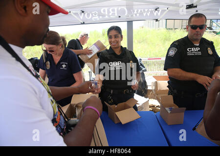 Stati Uniti Delle dogane e della protezione delle frontiere degli ufficiali dall'ufficio di operazioni sul campo passano fuori penne gratis come essi uomo un reclutamento di cabina all'Atlantic City, N.J., boardwalk durante l'Atlantic City Air Show il Agosto 17, 2016. Da Glenn Fawcett Foto Stock