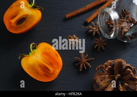 Superiore vista piana: anice star, bastoncini di cannella e persimmon Foto Stock