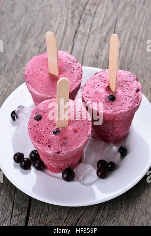 In casa popsicles ribes nero su sfondo di legno Foto Stock