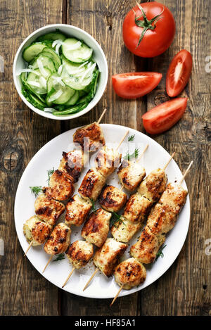 Barbeque, spiedini di pollo e verdure su sfondo di legno, vista dall'alto Foto Stock