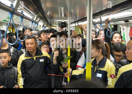 Hong Kong, Hong Kong. 27 Dic, 2016. Passeggeri celebrare come il primo treno passeggeri del sud dell'isola la linea di partenza. Centinaia di fan di MTR prendere il primo programma treno passeggeri dell'Isola Sud linea dal Sud Horizon stazione a stazione di Admiralty il giorno stesso per il funzionamento della linea. L'intero viaggio dura 11 minuti. L'isola del sud linea mira a rilievo la congestione del traffico il problema dell'Aberdeen tunnel durante le ore di punta. Il 28 dicembre 2016 © Alda Tsang/Pacific Press/Alamy Live News Foto Stock