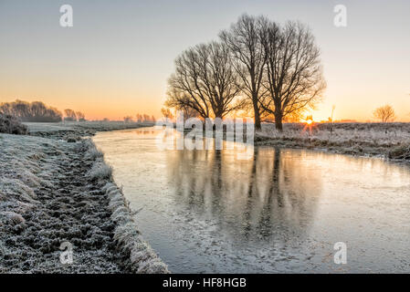 Willingham, Cambridgeshire, Regno Unito. 29 Dic, 2016. Il sole sorge su un congelati paesaggio Fenland sopra il vecchio West River. La temperatura è scesa a circa meno 4 gradi centigradi per tutta la notte con una diffusa il gelo e banchi di nebbia all'alba. © Julian Eales/Alamy Live News Foto Stock