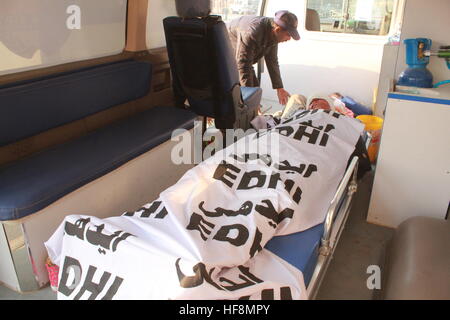 Abbottabad, Pakistan. 30 Dic, 2016. Un uomo in piedi vicino al corpo che stabilisce in ambulanza, almeno 5 persone uccise e 8 sostenere gravi lesioni durante l'incidente sulla KKH in Abbottabad. Credito: Sultan Dogar/Alamy Live News Foto Stock