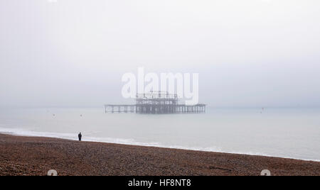 Brighton, Regno Unito. 30 Dic, 2016. Un camminatore solitario si affaccia al Molo di Ponente è avvolta nella nebbia lungo Brighton Seafront questa mattina come la nebbia e le basse temperature sono state previsioni per il sud dell'Inghilterra oggi © Simon Dack/Alamy Live News Foto Stock