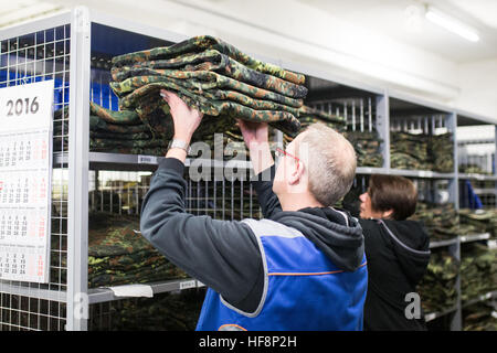 Un lavoratore di pile vestiti in Muenster, Germania, 06 dicembre 2016. Fino a 80.000 giovani sono forniti con circa 120 prodotti ogni anno nell'esercito tedesco in stazioni di servizio. I soldati di ricevere tutto da uniformi per il kit da campo, mostra, e abbigliamento sportivo. Foto: Marcel Kusch/dpa Foto Stock