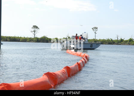 La risposta di inquinamento unità alla Naval Air Station Pensacola Fla., distribuisce l'olio barriere di contenimento a Sherman Cove per proteggere ecologicamente sensibili letti di erba dalla Deepwater Horizon oil spill Maggio 4, 2010. Deepwater Horizon era un ultra-deepwater oil rig che affondò Aprile 22, provocando una massiccia fuoriuscita di petrolio che minacciano la U.S. Costa del Golfo. (U.S. Navy foto di Patrick Nichols/RILASCIATO) 100504-N-6268N-027 (4581380809) Foto Stock