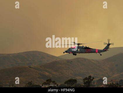 Un MH-60S Sea Hawk elicottero assegnato al mare in elicottero Combat Squadron (HSC) 3 prende il largo per assistere in estinzione dell'antenna a Camp Pendleton, California HSC-3 è assistere il reparto della California di selvicoltura e protezione antincendio fornendo personale di volo battenti appositamente attrezzate MH-60S elicotteri per condurre una antenna di gocce di acqua contro incendi in San Diego County. (U.S. Foto di Marina di Massa lo specialista di comunicazione 1a classe Joan E. Jennings/RILASCIATO) California incendi 140514-N-DX364-672 Foto Stock