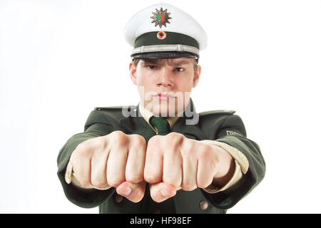 Giovane funzionario di polizia che si estende i suoi pugni Foto Stock