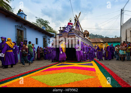 Antigua Guatemala - 16 Aprile 2014: un uomo che indossa vesti di porpora, portante un galleggiante (EUN) durante le feste pasquali in Antigua Foto Stock