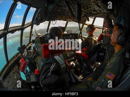 I soldati degli Stati Uniti a bordo di un Lockheed C-130 Hercules Circolo aereo un'isola mentre si pratica air drop procedure per il funzionamento di caduta di natale missione umanitaria Dicembre 5, 2016 in le isole della Micronesia. Foto Stock