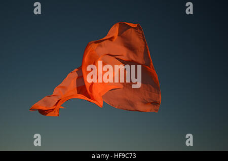 Foulard arancione battenti al sole con lo sfondo del cielo Foto Stock