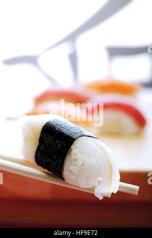 Bacchette tenendo il nigiri sushi Foto Stock