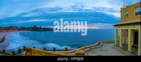 Sunrise over Coogee Beach e Coogee Beach Surf Life saving Club, a Sydney Australia su una mattina nuvoloso Foto Stock