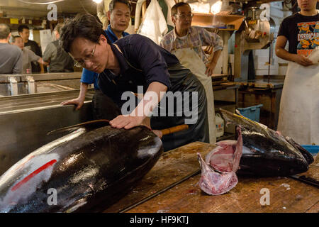 L'uomo il taglio di un tonno alla testa. Mercato Tsukiji, Tokyo, Giappone. Foto Stock