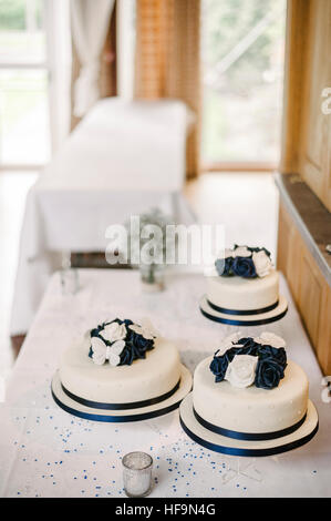 Tre bianchi torte nuziali di bianco e blu con cake topper. Foto Stock