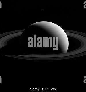 La sonda Cassini della NASA cattura un'immagine della luna di Saturno Teti che passa davanti al sistema di anelli del pianeta. L'immagine evidenzia la luna ghiacciata e la sua orbita attorno al gigante gassoso Saturno. Foto Stock