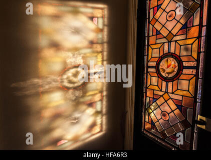 Le vetrate colorate colori e fantasie proiettate sul muro dalla luce del sole. Foto Stock