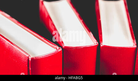 Vecchio rosso enciclopedie in pelle legato su sfondo nero Foto Stock