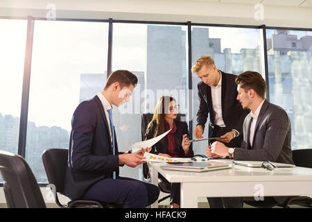 Un gruppo di imprenditori che lavorano insieme ad un tavolo all'offic Foto Stock