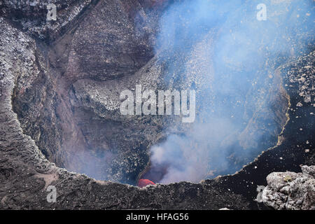 Esaminando il Santiago attivo cratere vulcanico a Masaya, Nicaragua con gas emesso continuamente e la lava può essere visto Foto Stock