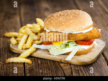 Hamburger di pesce (messa a fuoco selettiva; close-up shot) su sfondo di legno Foto Stock