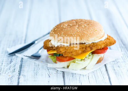 Hamburger di pesce (messa a fuoco selettiva; close-up shot) su sfondo di legno Foto Stock