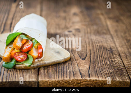 Wrap di pollo (dettagliate di close-up shot; messa a fuoco selettiva) su sfondo di legno Foto Stock