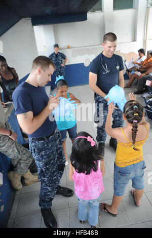 Petty Officer di terza classe Josh Whoolery, ospedale corpsman, marinaio e Dana Scott, hospital corpsman, girare i guanti di gomma in palloncini per una Costa Rican boy durante un partenariato Pacifico 2010 comunità evento di assistenza. Il multipurpose Amphibious Assault nave USS Iwo Jima è su una porta visita al Limon conducendo la continua promessa 2010 umanitario assistenza civica di missione. Il medico assegnato e il personale tecnico imbarcato a bordo di Iwo Jima lavorerà con la nazione partner in grado di fornire i team di medico, dentista, veterinario e assistenza tecnica in otto diverse nazioni. Continuando la promessa 2010 acti Foto Stock