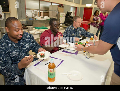 140418-N-OX321-255 NAVAL AIR FACILITY Atsugi, Giappone (18 aprile 2014) - Naval Air Facility (NAF) Comando di Atsugi Master Chief Michael Wilkins, diritto, specialista culinaria 2a classe Sherland Douglas, sinistra e specialista culinaria di terza classe Paolo Gyabaah, entrambi di NAF Atsugi il Lontano Oriente Cafe, preparatevi a gustare un partecipante la presentazione finale come giudici per NAF Atsugi's Top Little Chef Sushi sfida. La manifestazione consisteva di nove figli da Shirley Lanham Scuola elementare e faceva parte del mese del bambino militare celebrazione. I partecipanti sono stati giudicati sulla loro presentazione, uso di ingredi Foto Stock