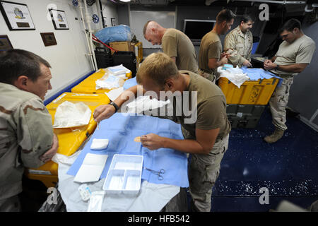 I membri di Stati Uniti La guardia costiera della tattica di applicazione della legge, det. 404 pratica semplice suture interrotta durante il combattimento casualty cura la formazione medica a bordo guidato-missili cruiser USS Princeton. Princeton è assegnato alla combinazione di Task Force 151, una task force multinazionale istituita nel gennaio 2009 per condurre una lotta alla pirateria operazioni in e attorno al Golfo di Aden e bacino somalo. CTF-151 336801 Foto Stock