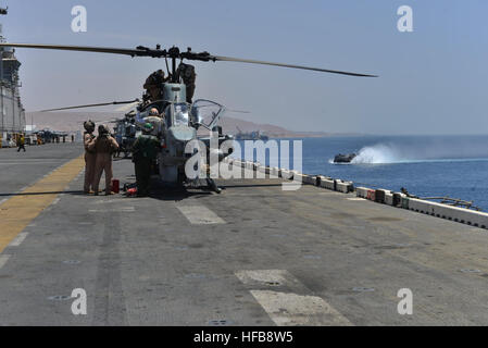 Stati Uniti Marine Corps piano capitani condurre controlli preflight su un Marine Corps AH-1W Super elicottero Cobra a bordo dell'assalto anfibio nave USS Bataan (LHD 5) come una landing craft, cuscino d'aria si avvicina alla nave Maggio 23, 2014, in Aqaba Giordania, durante l'esercizio desiderosi Lion 2014. Desiderosi di Lion è un U.S. Comando centrale-diretto esercizio inteso a rafforzare strutture militari le relazioni tra gli Stati Uniti e la Giordania. (U.S. Foto di Marina di Massa lo specialista di comunicazione di terza classe Erik Foster/RILASCIATO) desiderosi Lion 14 140523-N-HO612-077 Foto Stock