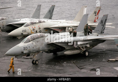 Assistenza Aeromobili equipaggio spazzola neve e ghiaccio fuori le ali di un Fighter Squadron 111 (VF-111) F-14A Tomcat aerei durante le operazioni di volo a bordo della energia nucleare portaerei USS CARL VINSON (CVN-70). F-14come VF-111 sulla USS Carl Vinson (CVN-70) 1987 Foto Stock