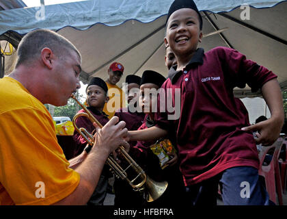 120616-N-KK935-059 LUMUT, Malaysia (16 giugno 2012) musicista 2a classe Matt Kinaman, membro dell'U.S. 7 Flotta Brass Band, incoraggia un bambino per assisterlo nel suonare la tromba durante un servizio alla comunità il progetto presso Haruman Kasih Pertubuhan Casa delle Carità per la cooperazione a galla la prontezza e la formazione (Carati) Malaysia 2012. Carato è una serie di accordi bilaterali di esercitazioni militari tra Stati Uniti La marina e le forze armate del Bangladesh, Brunei, Cambogia, Indonesia, Malaysia, Filippine, Singapore e la Thailandia. Timor orientale si unisce a CARAT per la prima volta nel 2012. (U.S. Foto di Marina di Massa Comm Foto Stock