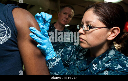 120904-N-OY799-018 OCEANO PACIFICO (sett. 4, 2012) Ospedale Corpsman 1a classe Diana Rodriguez amministra un virus del vaiolo vaccino per un paziente sul pasticcio ponti della Nimitz-class portaerei USS John C. Stennis CVN (74) durante le immunizzazioni. John C. Stennis è ritorno negli Stati Uniti 7 e 5a flotta aree di responsabilità quattro mesi di anticipo rispetto alla pianificazione al fine di mantenere il comandante combattente requisiti per la presenza nella regione. (U.S. Foto di Marina di Massa lo specialista di comunicazione di terza classe Kenneth Abbate/rilasciato) - UFFICIALE DEGLI STATI UNITI Le immagini della marina - un marinaio amministra un virus del vaiolo vaccino. Foto Stock